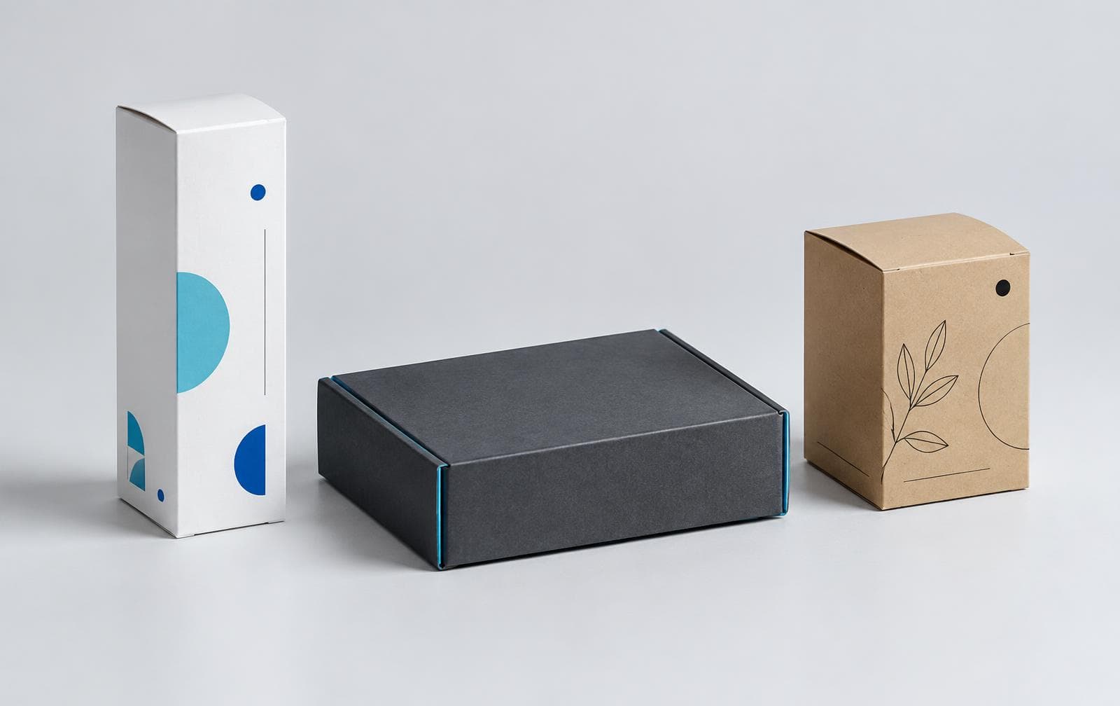 A white carton, charcoal mailer, and kraft paper box representing different packaging structures and finishes